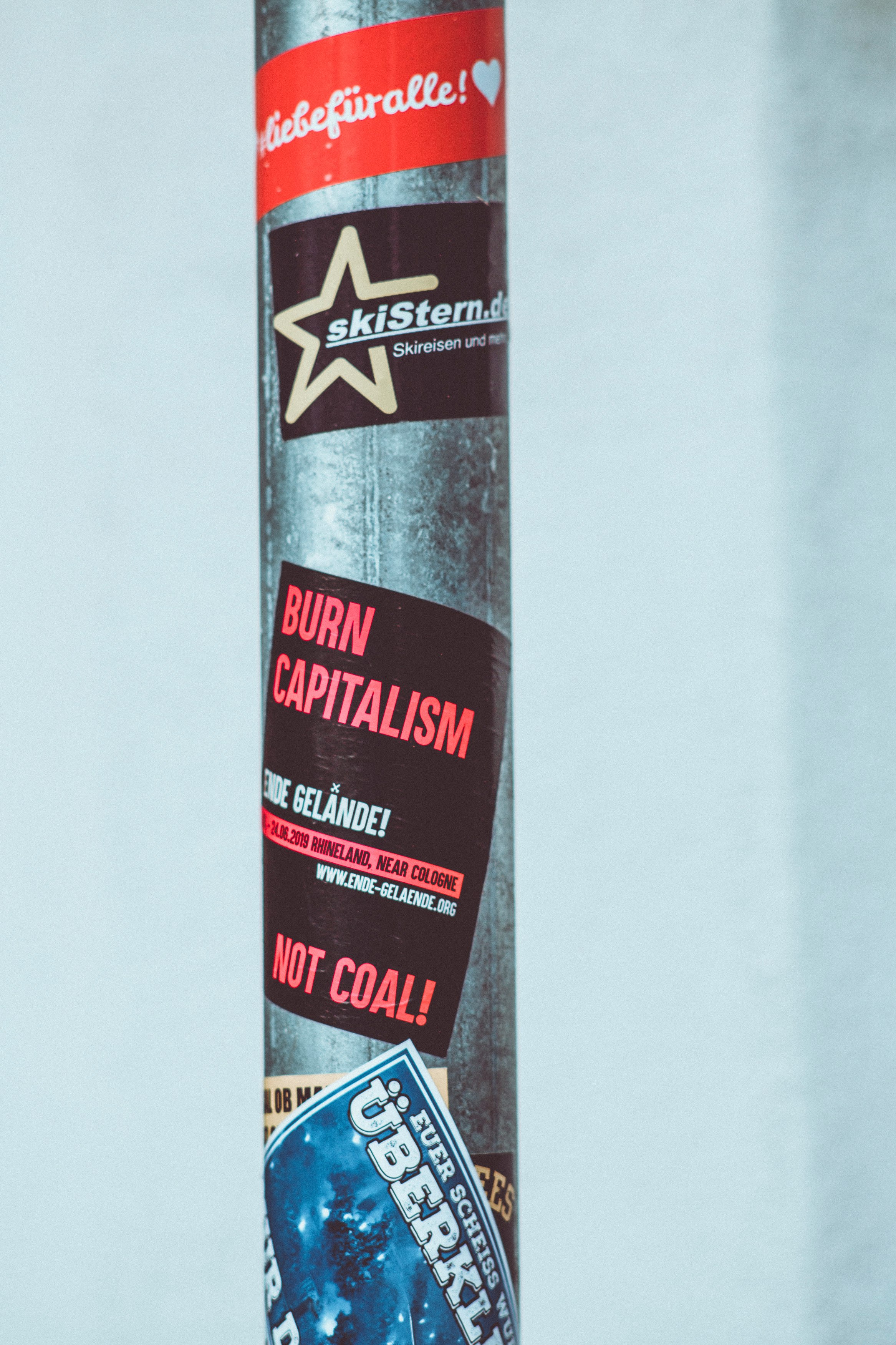 stickers on a gray metal pole